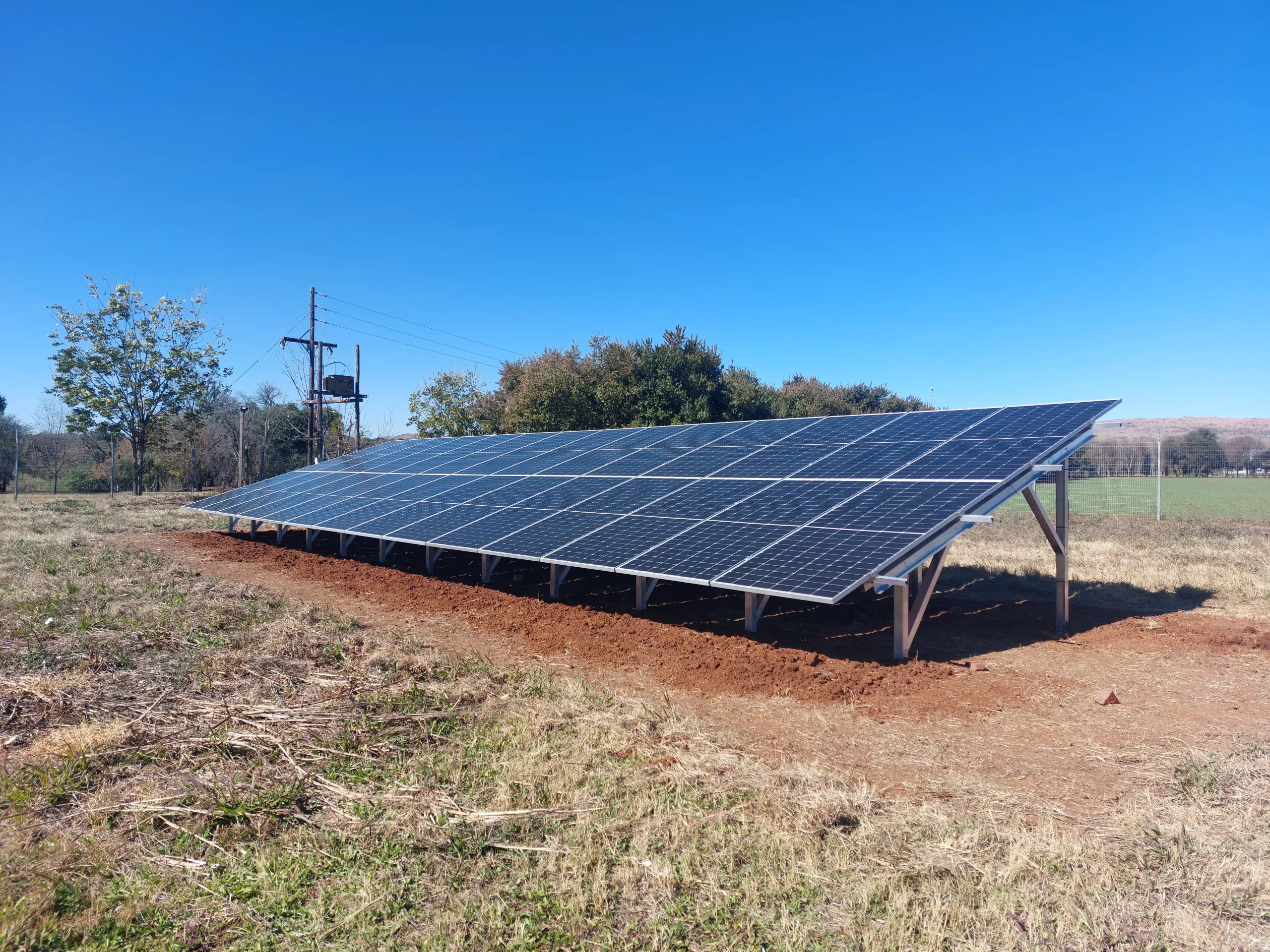 Solar PV panel installation by Powermode amidst a scenic farm landscape, powering sustainable agriculture.